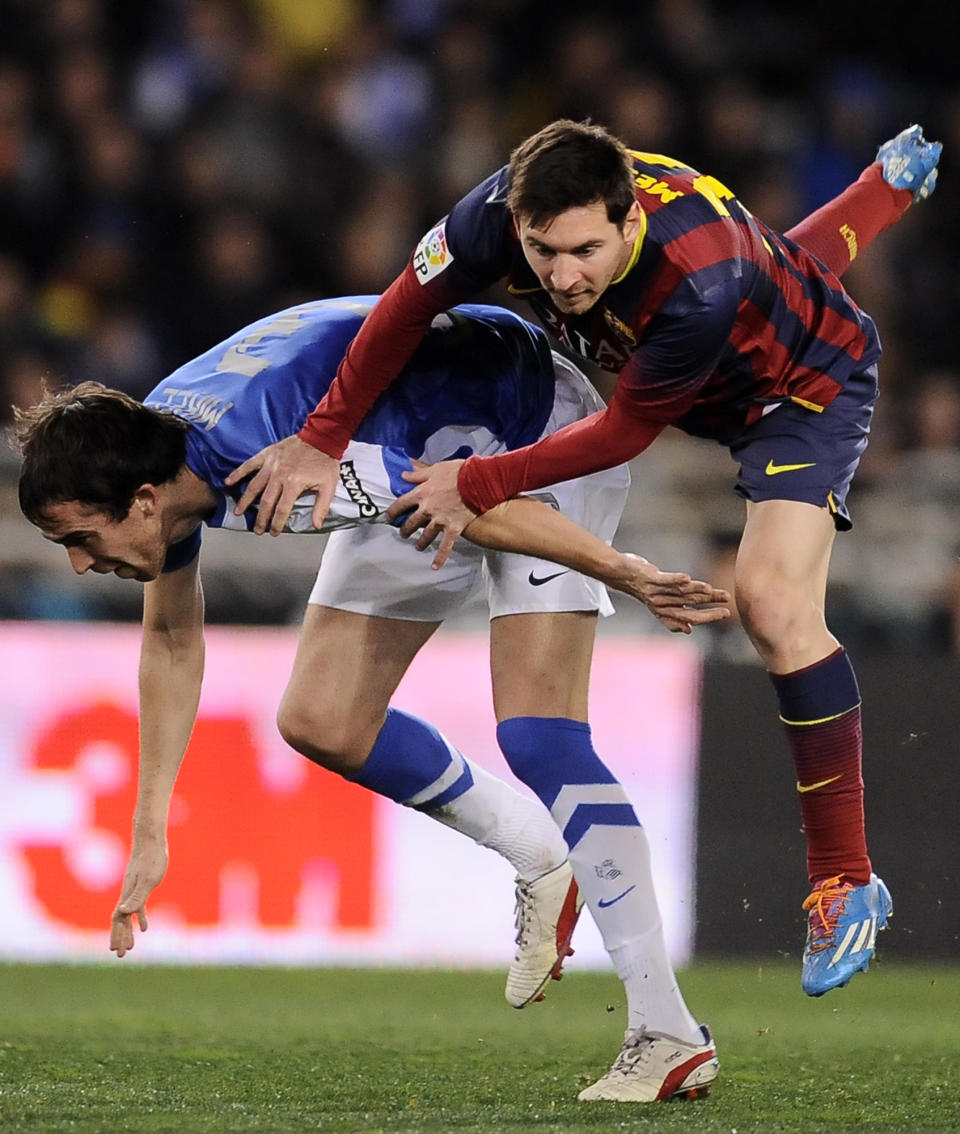 FC Barcelona's Lionel Messi of Argentina, right, clashes with Real Sociedad's Mikel Gonzalez, during their Spanish Copa del Rey semifinal second leg soccer match, at Anoeta stadium, in San Sebastian northern Spain, Wednesday, Feb. 12, 2014. (AP Photo/Alvaro Barrientos)