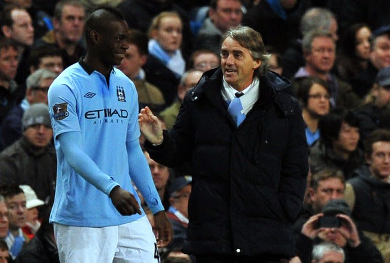 Manchester City's Mario Balotelli (L) shares a joke with manager Roberto Mancini when coming on as a substitute during the FA Cup third-round clash against Watford on January 5, 2013. Mancini admitted he will be disappointed to see "one of my children" Balotelli leave Manchester for AC Milan but insists the move is in the best interests of the Italy forward