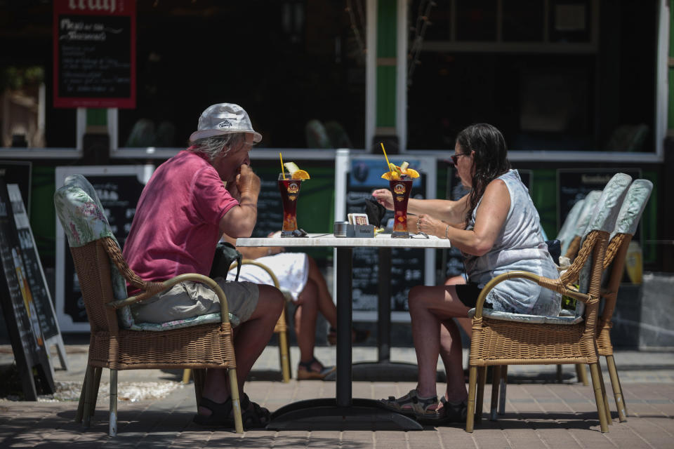 German tourists sit at a bar terrace in Palma de Mallorca, Spain, Monday, June 15, 2020. Borders opened up across Europe on Monday after three months of coronavirus closures that began chaotically in March. But many restrictions persist, it's unclear how keen Europeans will be to travel this summer and the continent is still closed to Americans, Asians and other international tourists. (AP Photo/Joan Mateu)