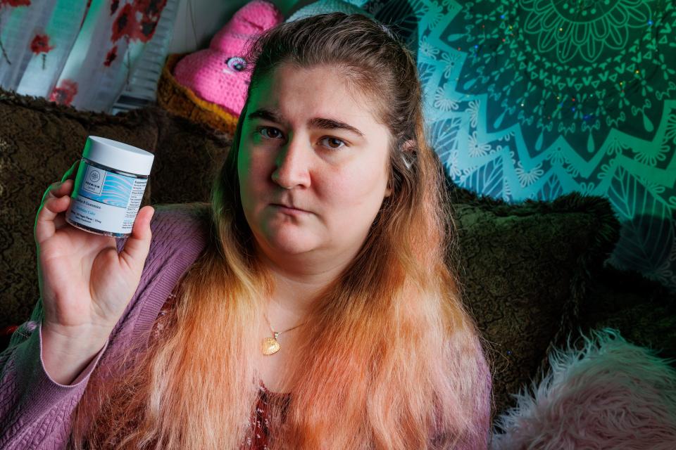 Jessica Watkins, at her home in Arlington, Texas, holds a jar of delta-8 gummies that caused a bad physical reaction.