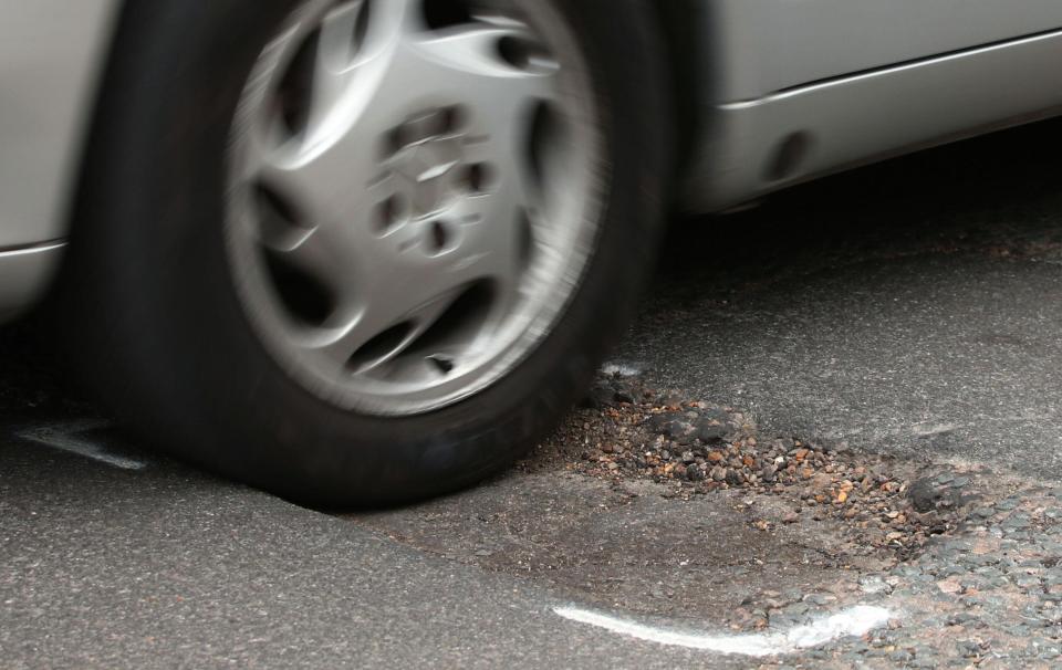 File photo dated 11/05/18 of a car hitting a pothole on a road. Drivers are suffering from a surge in pothole-related breakdowns, new figures from the RAC suggest.