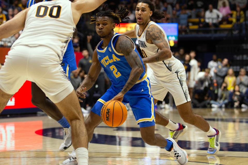 UCLA Bruins guard Dylan Andrews (2) drives to the basket between California Golden Bears defenders Fardaws Aimaq (00) and Jaylon Tyson (20) during the second half at Haas Pavilion Feb. 10, 2024, in Berkeley, California.