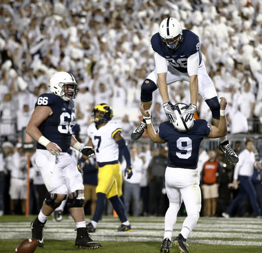 Penn State’s Mike Gesicki (88) celebrates by jumping over quarterback Trace McSorley (9) after McSorley scored a touchdown against Michigan during the first half of an NCAA college football game in State College, Pa., Saturday, Oct. 21, 2017. (AP Photo/Chris Knight)