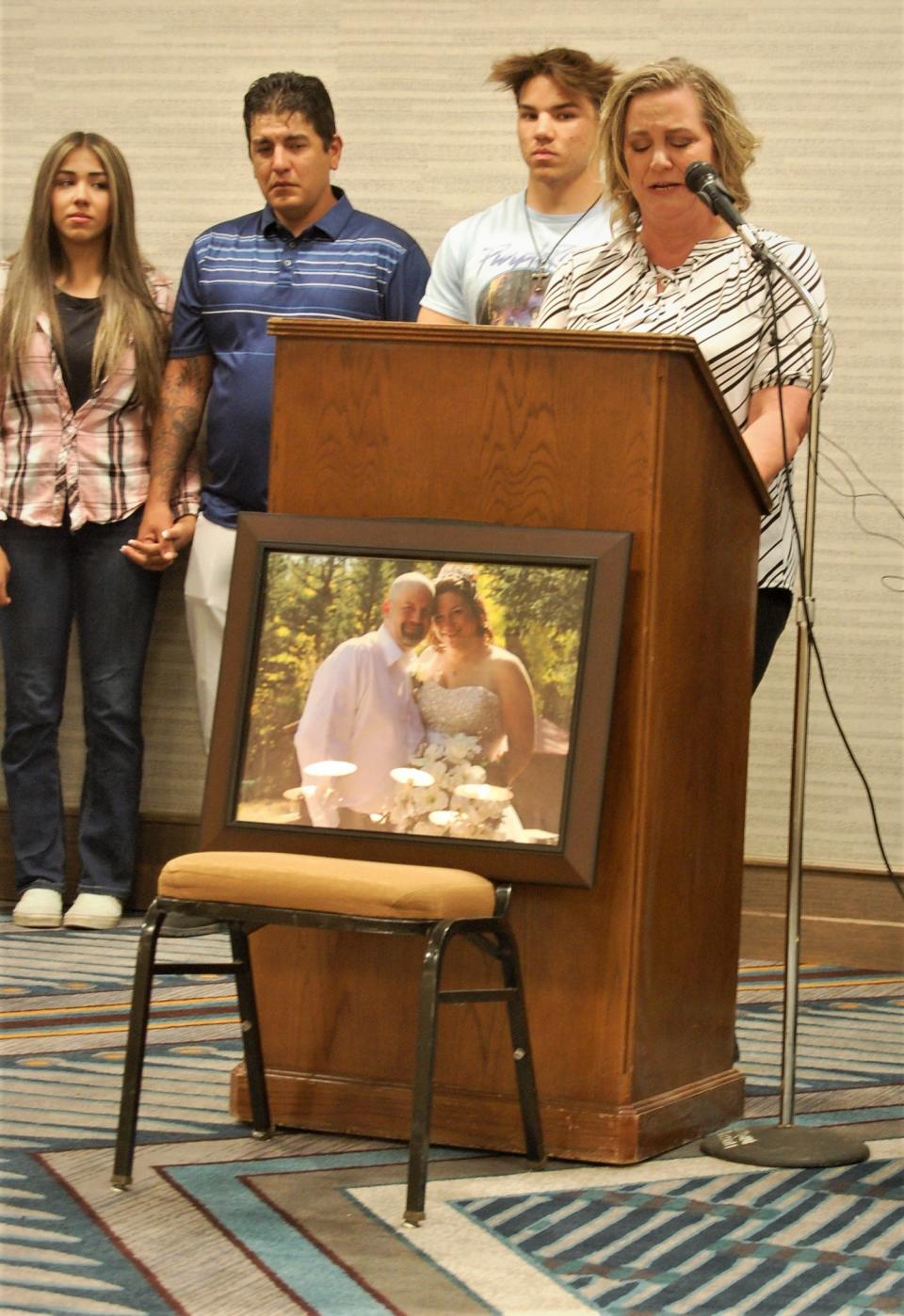 With members of her family standing nearby, Kim Dotson -- the widow of shooting victim Robert Dotson -- speaks during a Thursday, April 20 press conference at the Courtyard by Marriott hotel in Farmington.