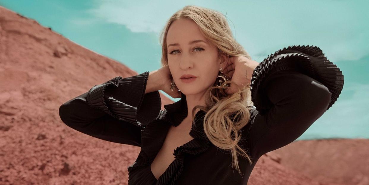 margo price stands in front of a red sand mountain