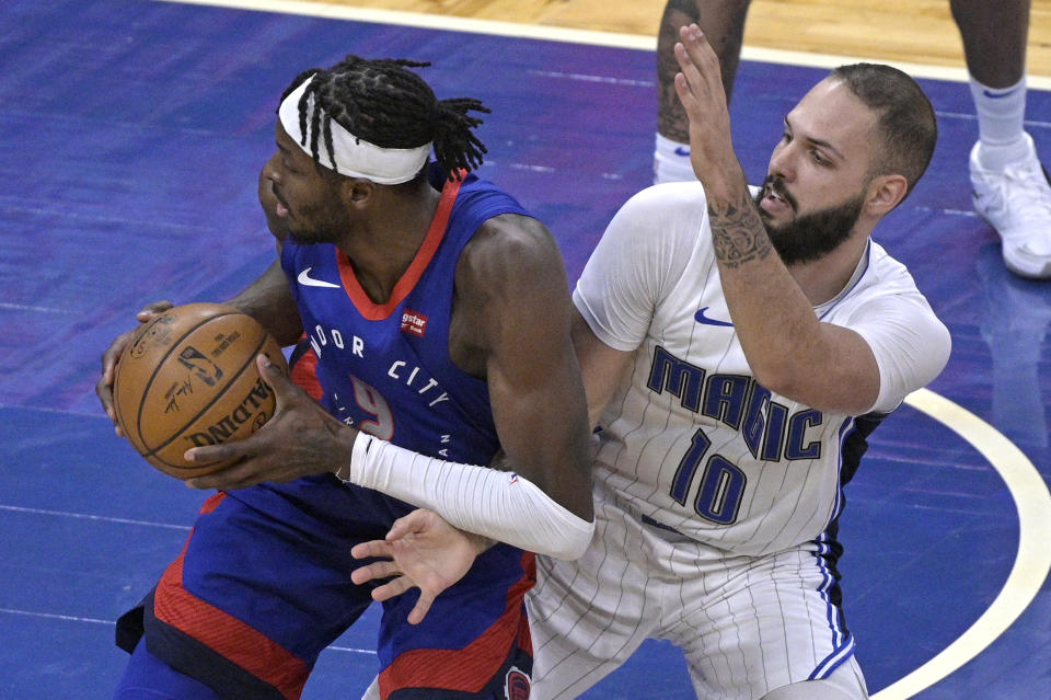 Detroit Pistons forward Jerami Grant (9) spins to the basket while defended by Orlando Magic guard Evan Fournier (10) during the second half of an NBA basketball game, Tuesday, Feb. 23, 2021, in Orlando, Fla. (AP Photo/Phelan M. Ebenhack)