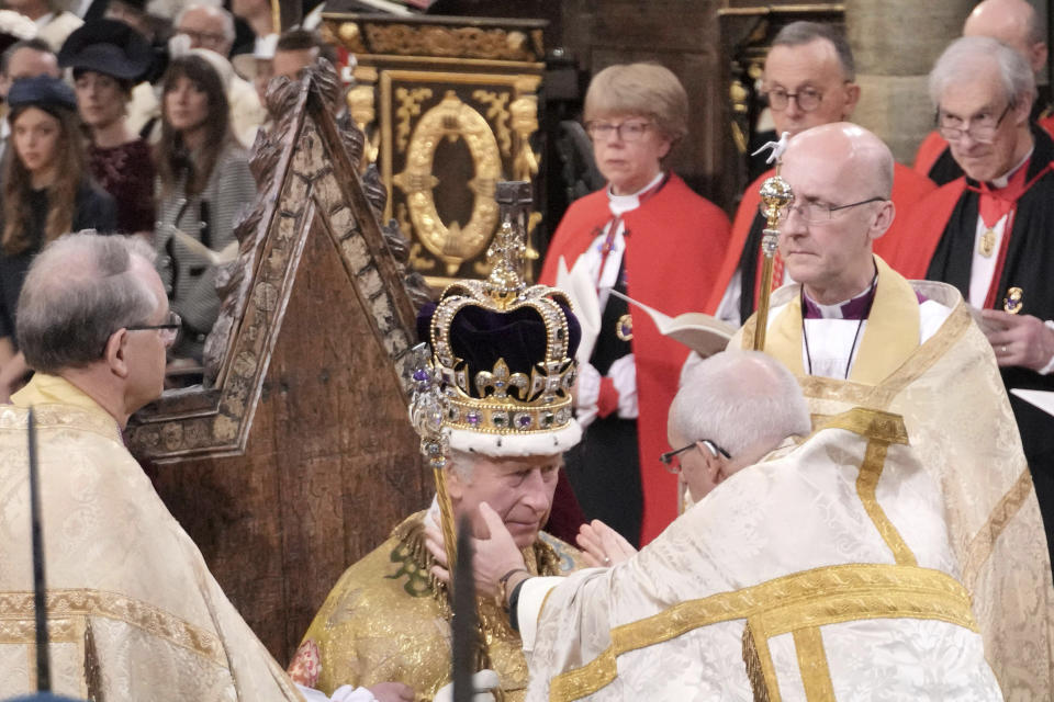 El rey Carlos III sentado mientras es coronado con la corona de San Eduardo por el arzobispo de Canterbury, el reverendo Justin Welby, durante la ceremonia de coronación en la Abadía de Westminster en Londres, el sábado 6 de mayo de 2023. (Jonathan Brady/Pool Photo vía AP)