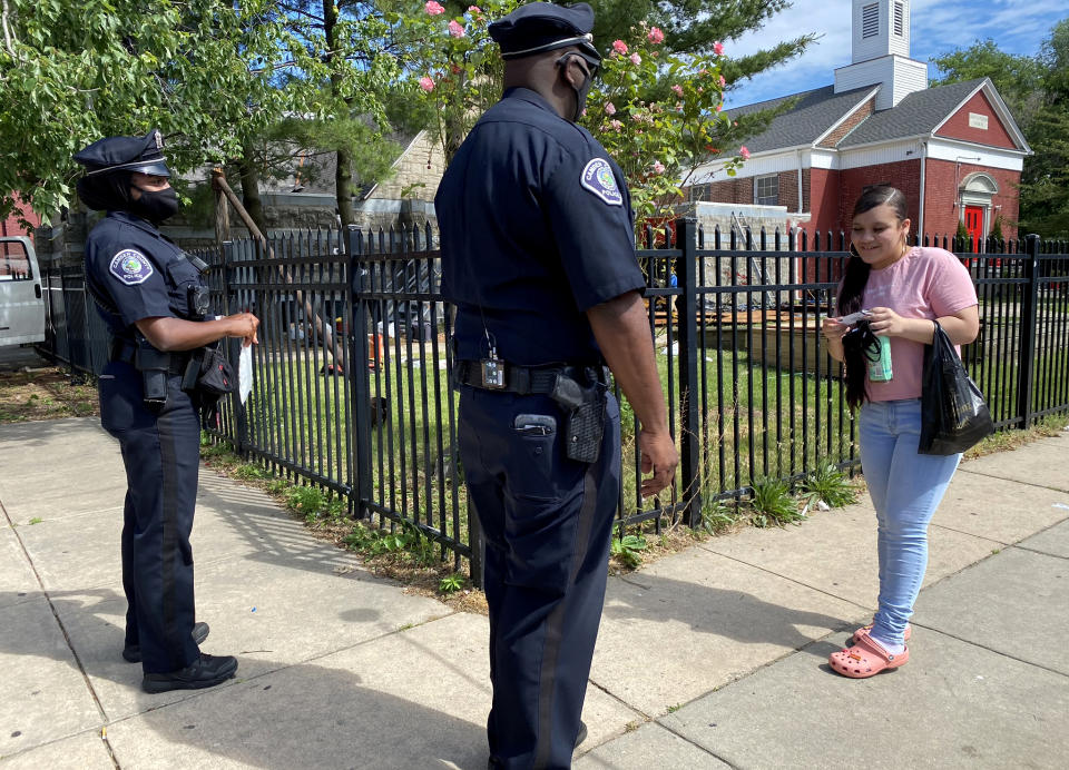 Image: Camden County Metro Police Lt. Zack James and Officer Mayah Bailey speak to a resident. (Kenzi Abou-Sabe / NBC News)