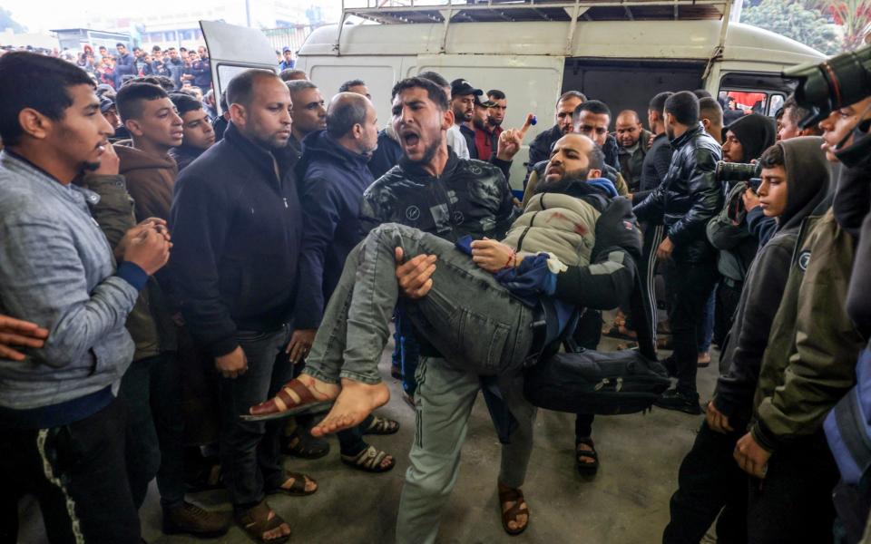 Palestinians wounded during Israeli bombardment are carried into Nasser hospital in Khan Yunis in the southern Gaza Strip