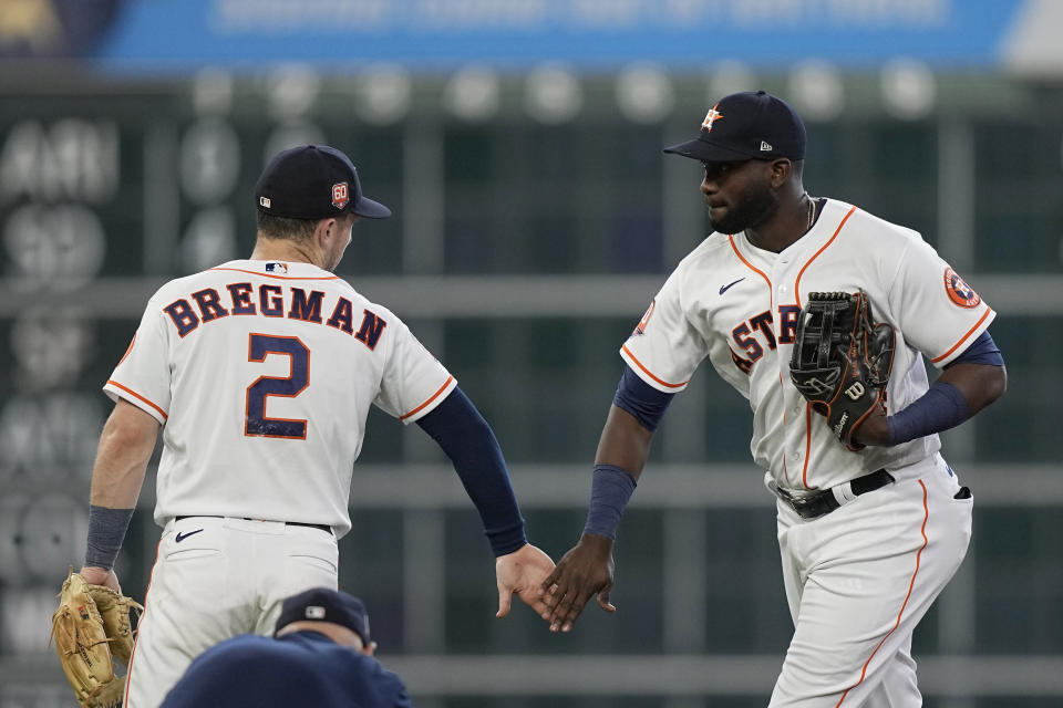 Houston Astros' Alex Bregman (2) and Yordan Alvarez celebrate after a baseball game against the New York Mets Wednesday, June 22, 2022, in Houston. The Astros won 5-3. (AP Photo/David J. Phillip)