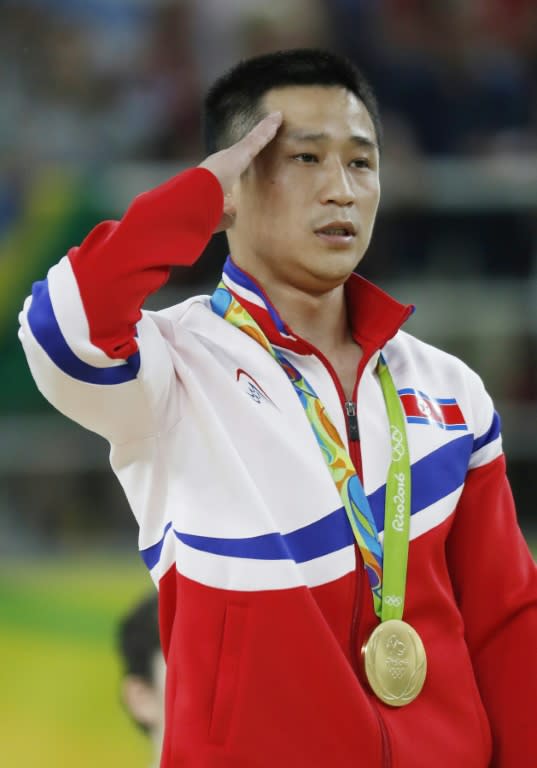 North Korea's Ri Se Gwang salutes as he listens to his national anthem during the podium of the men's vault event final in Rio de Janeiro on August 15, 2016