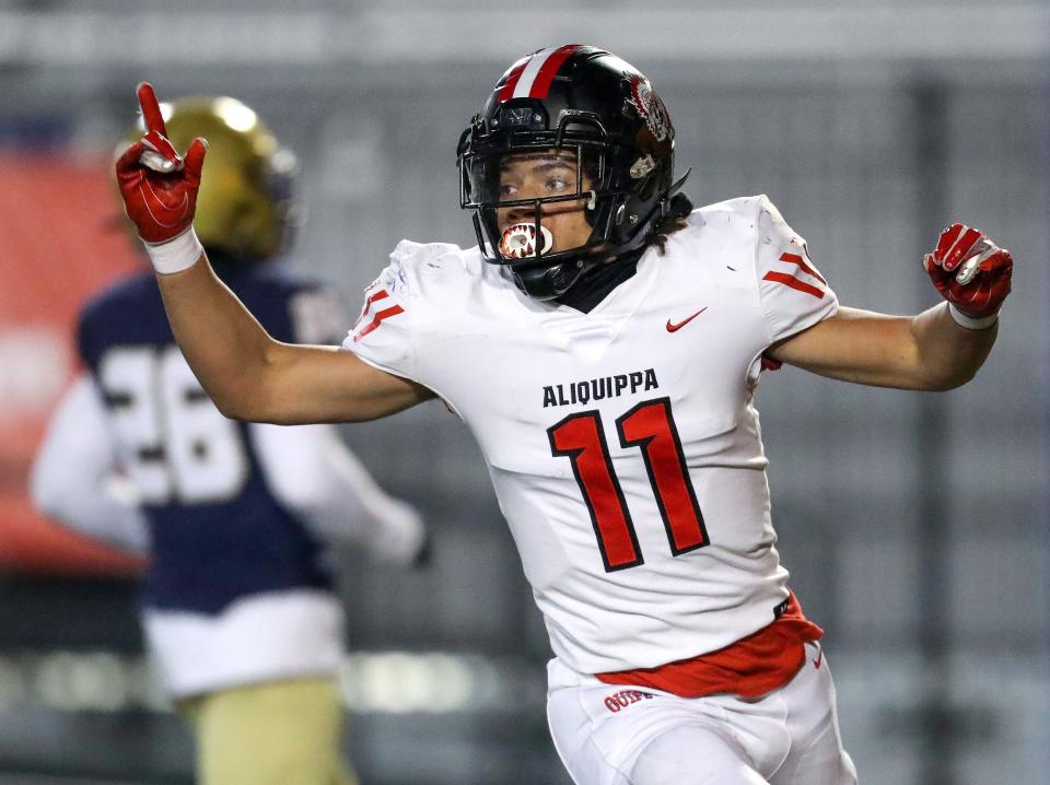 Aliquippa's Cameron Lindsey (11) celebrates after scoring a touchdown following an interception against Bishop McDevitt in the first quarter of the PIAA Class 4A championship football game, Dec. 9, 2021, at HersheyPark Stadium in Hershey. The Quips defeated the Crusaders 34-27. 