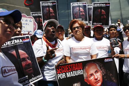 Opposition supporters hold pictures of jailed opposition leader, Antonio Ledezma, during a rally to commemorate International Women's Day and in support of him and the jailed opposition leader, Leopoldo Lopez, in Caracas, March 8, 2015. REUTERS/Carlos Garcia Rawlins