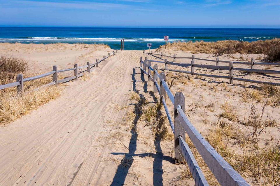 <p>KenWiedemann/Getty Images</p> A sandy path leads to Coast Guard Beach in the Cape Cod National Seashore