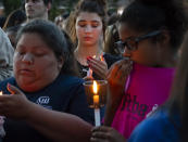 <p>Santa Fe High School student Hunter Kana, center, holds a lighted candle during a vigil held in the wake of a deadly school shooting with multiple fatalities at Santa Fe High School on Friday, May 18, 2018, in Santa Fe, Texas. (Photo: Stuart Villanueva/The Galveston County Daily News via AP) </p>