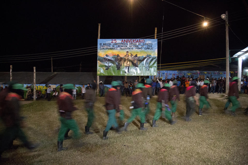 Members of the Zapatista National Liberation Army, EZLN, arrive to an event marking the 25th anniversary of the Zapatista uprising, in La Realidad, Chiapas state, Mexico, late Monday, Dec. 31, 2018. (AP Photo/Eduardo Verdugo)