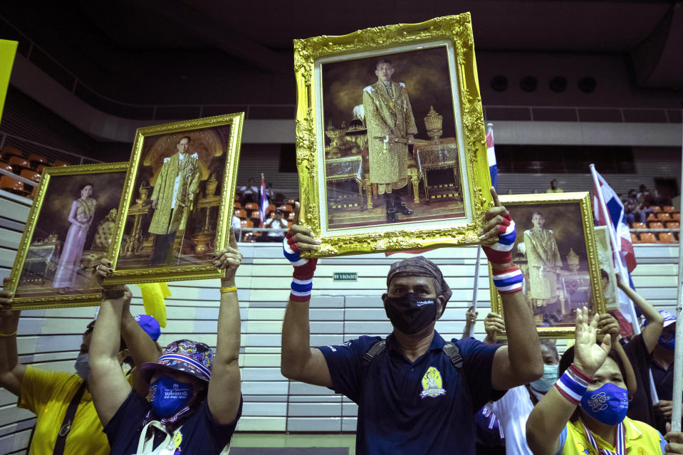 Supporters of the Thai monarchy hold up images of King Maha Vajiralongkorn and Queen Suthida during a rally in Bangkok, Thailand, Sunday Aug. 30, 2020. A two-day rally planned for this weekend is jangling nerves in Bangkok, with apprehension about how far student demonstrators will go in pushing demands for reform of Thailand’s monarchy and how the authorities might react. More than 10,000 people are expected to attend the Saturday-Sunday event. (AP Photo/Sakchai Lalit)