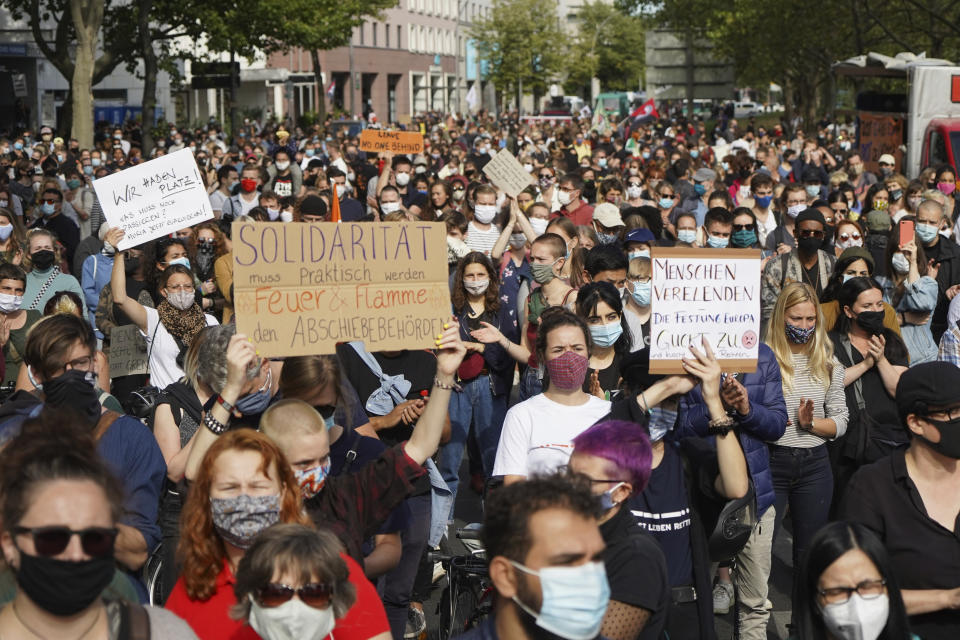 Participants in a demonstration of an alliance for the immediate evacuation of all Greek camps hold protest signs in Berlin, Germany, Sunday, Sept.20, 2020. The alliance of Pro Asyl, the Berlin pier and other groups is calling on the federal government to stop blocking the reception of local and state authorities. (Joerg Carstensen/dpa via AP)