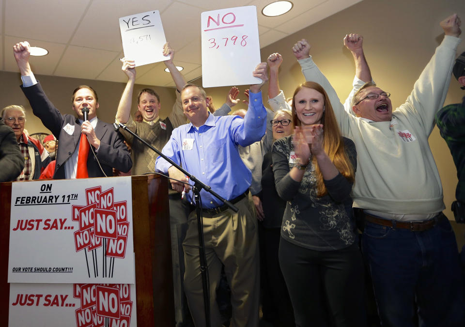 State Sen. Charlie Jansssen of Fremont, second left, Jeremy Jensen, third left, and John Wiegert, center, celebrate with other activists in Fremont, Neb., Tuesday, Feb. 11, 2014, after city voters have decided by voting no, to uphold the law designed to bar immigrants from renting homes if they don’t have legal permission to be in the U.S. (AP Photo/Nati Harnik)