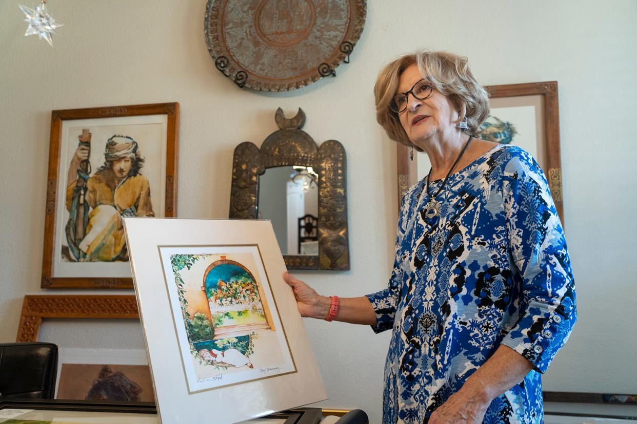 Kathleen Stafford discusses a watercolor she painted. Her active studio is full of well-employed art supplies and singular inspirational art.