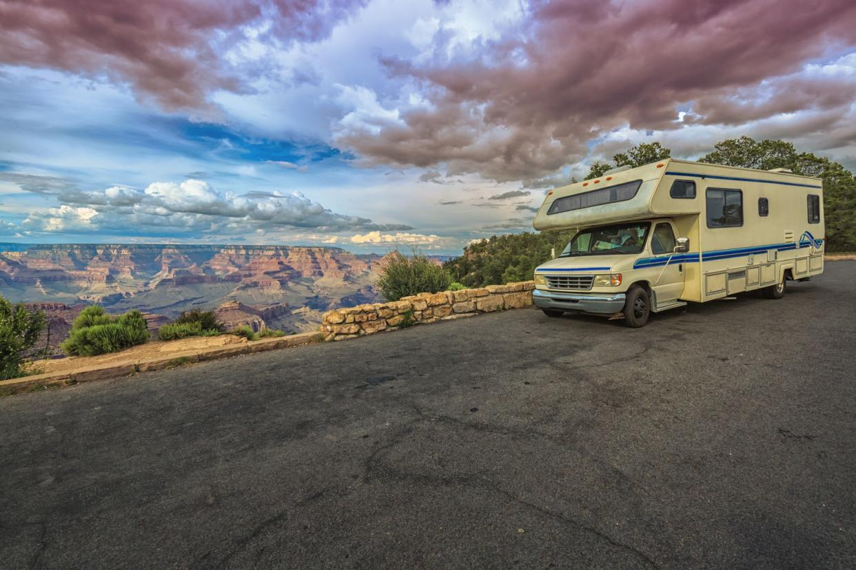RV stopped on the side of the road with a magnificent view of the The Grand Canyon at sunset in the background