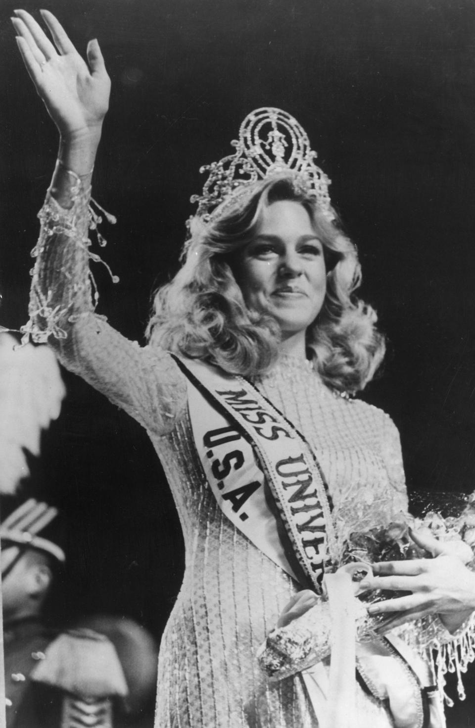 Miss USA Shawn Weatherly waves wearing a tiara and a Miss USA and Miss Universe sash.