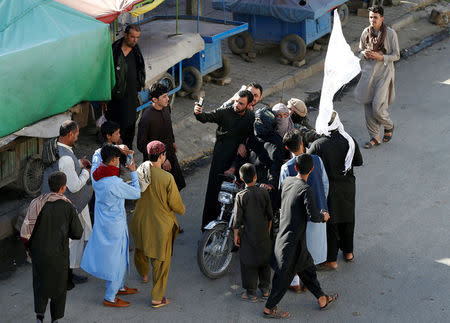 People take selfies with the Taliban in Kabul, Afghanistan June 16, 2018. REUTERS/Mohammad Ismail