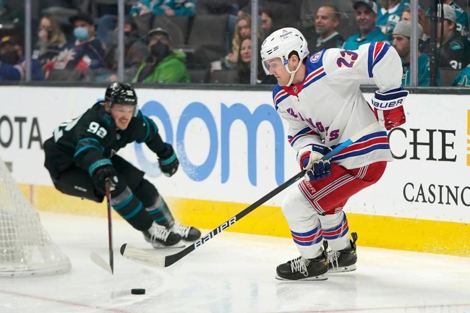 New York Rangers defenseman Adam Fox (23) skates with the puck against San Jose Sharks left wing Rudolfs Balcers (92) during the first period of an NHL hockey game in San Jose, Calif., Thursday, Jan. 13, 2022. (AP Photo/Jeff Chiu)