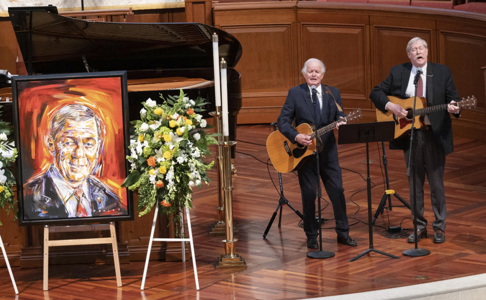 Banks and Shane perform "God Bless America" beside a portrait of former Sen. Johnny Isakson during a funeral service for Isakson at Peachtree Road United Methodist Church, Thursday afternoon, Jan. 6, 2022, in Atlanta. Isakson, 76, died Dec. 19, 2021, at his home in Atlanta. (Ben Gray/Atlanta Journal-Constitution via AP)