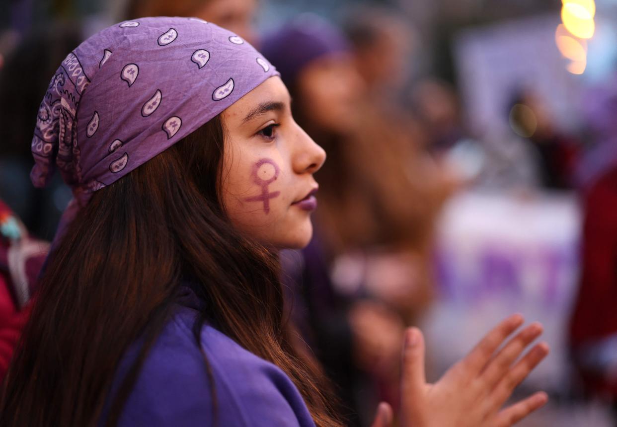 A woman with the feminist symbol of venus painted on her face takes part in a demonstration marking the International Women's Day in Madrid.