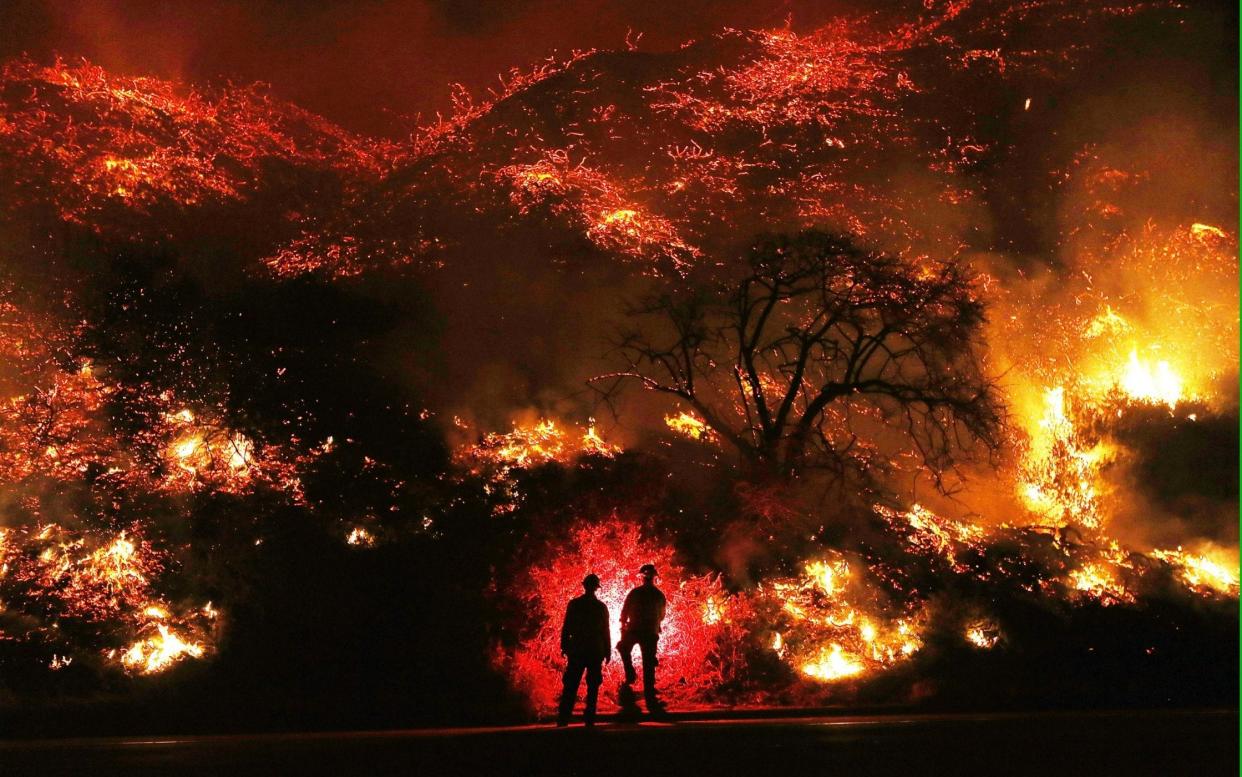 Firefighters monitor a section of the Thomas Fire along the 101 freeway north of Ventura, California - Getty Images North America