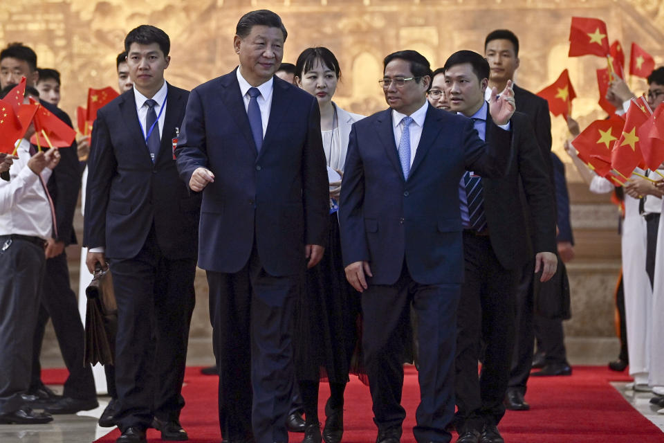 Vietnam's Prime Minister Pham Minh Chinh, center right, bids farewell to China's President Xi Jinping, center left, after their meeting at the Government Office in Hanoi Wednesday, Dec. 13, 2023. (Nhac Nguyen/Pool Photo via AP)