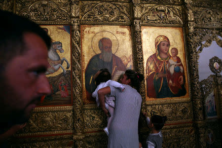 Pilgrims kiss Greek Orthodox icons in the Church of the Monastery of Apostolos Andreas in north-eastern Cyprus after the structure was reopened after two years of renovation, Cyprus November 7, 2016. REUTERS/Yiannis Kourtoglou