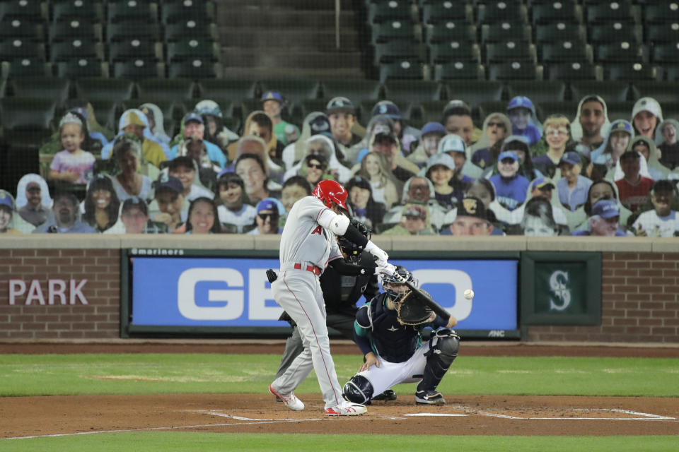 Los Angeles Angels' Shohei Ohtani hits a solo home run as Seattle Mariners catcher Joe Hudson looks on during the second inning of a baseball game, Thursday, Aug. 6, 2020, in Seattle. (AP Photo/Ted S. Warren)