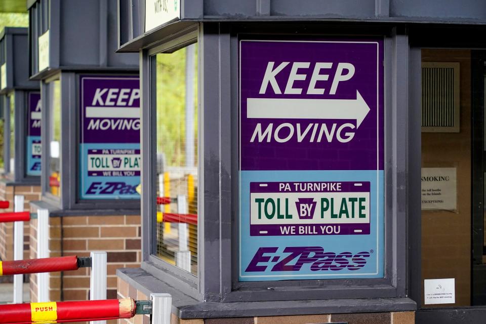 FILE - Signs on the electronic toll booths indicate to motorists entering the Pennsylvania Turnpike in Gibsonia to keep moving, and the methods being used to collect tolls.