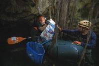 Biologist Roberto Rojo, left, collects garbage from a cenote with a volunteer from the group "Cenotes Urbanos," or Urban Cenotes, a local environmental organization in Playa del Carmen, Mexico, Saturday, March 2, 2024. These glowing sinkhole lakes, known as cenotes, are a part of one of Mexico's natural wonders: A fragile system of thousands of subterranean caverns, rivers, and lakes that wind beneath Mexico's southern Yucatan peninsula. (AP Photo/Rodrigo Abd)