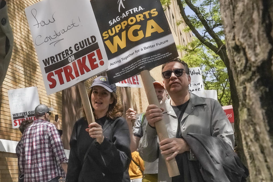 Actors and comedians Tina Fey, center, and Fred Armisen, right, join striking members of the Writers Guild of America on the picket line, during a rally outside Silvercup Studios, Tuesday May 9, 2023, in New York. (AP Photo/Bebeto Matthews)