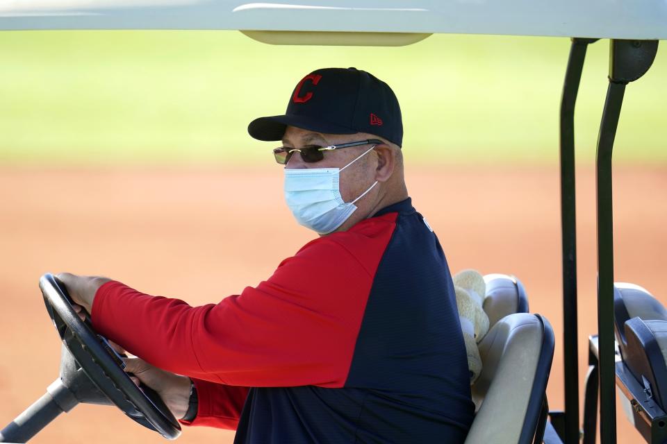 Cleveland Indians manager Terry Francona wears a face covering as he drives around on a golf cart during a spring training baseball practice Monday, Feb. 22, 2021, in Goodyear, Ariz. (AP Photo/Ross D. Franklin)