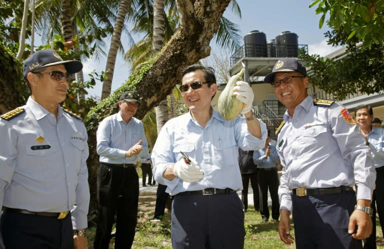 Taiwan President Ma Ing-jeou (C) holding up a papaya during his Jan 28 visit to Taiping island, located in the disputed Spratly islands in the South China Sea