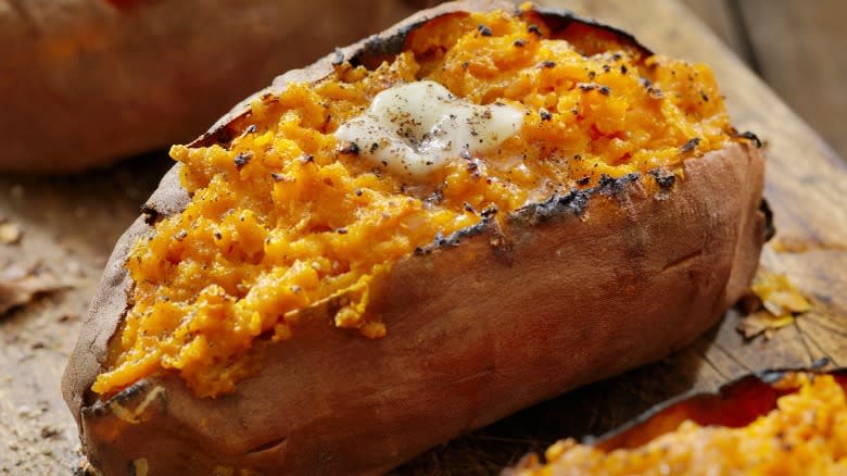 Closeup of a baked sweet potato with butter and spices