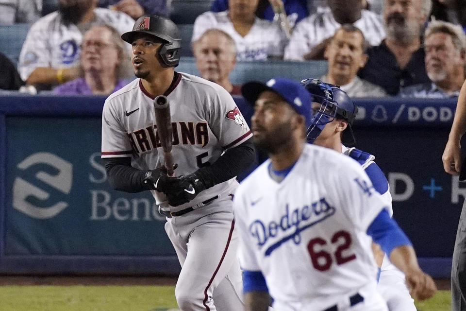Arizona Diamondbacks' Eduardo Escobar, left, heads to first after hitting a two-run home run off Los Angeles Dodgers relief pitcher Darien Nunez, foreground, during the fifth inning of a baseball game Friday, July 9, 2021, in Los Angeles. (AP Photo/Mark J. Terrill)