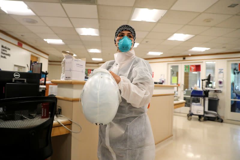 Zafia Anklesaria, codirectora de la unidad de cuidados intensivos en el Centro Médico del Hospital Dignity Health California de CommonSpirit, de 35 años y con siete meses de embarazo, se coloca un traje protector para atender a un paciente donde trabaja en medio del brote de coronavirus en Los Angeles, California, EEUU