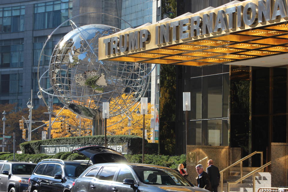 New York City, USA - November 14, 2016: Trump International Hotel and Tower in NYC at 1 Central Park West on Columbus Circle in front of the entrance of the building with several tourists or local people and cars lined up in front of the hotel.