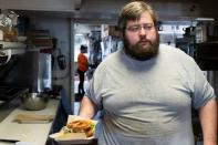 Brady Peterson, owner and chef of Pete's, a barbecue restaurant, prepares a sandwich in Smith Center, Kansas