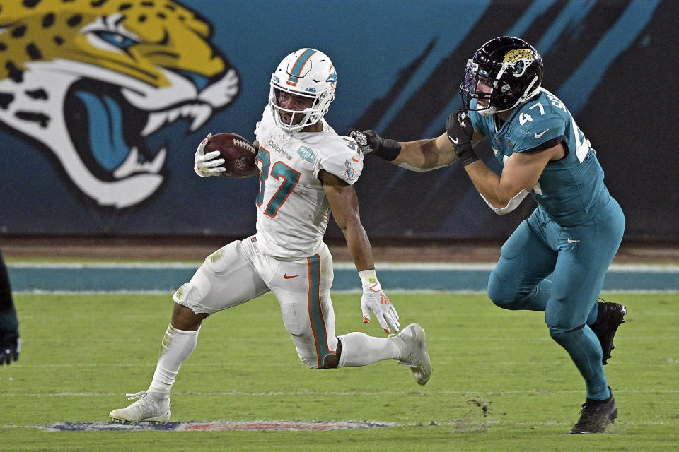 Miami Dolphins running back Myles Gaskin, left, runs past Jacksonville Jaguars middle linebacker Joe Schobert (47) during the first half of an NFL football game, Thursday, Sept. 24, 2020, in Jacksonville, Fla. (AP Photo/Phelan M. Ebenhack)
