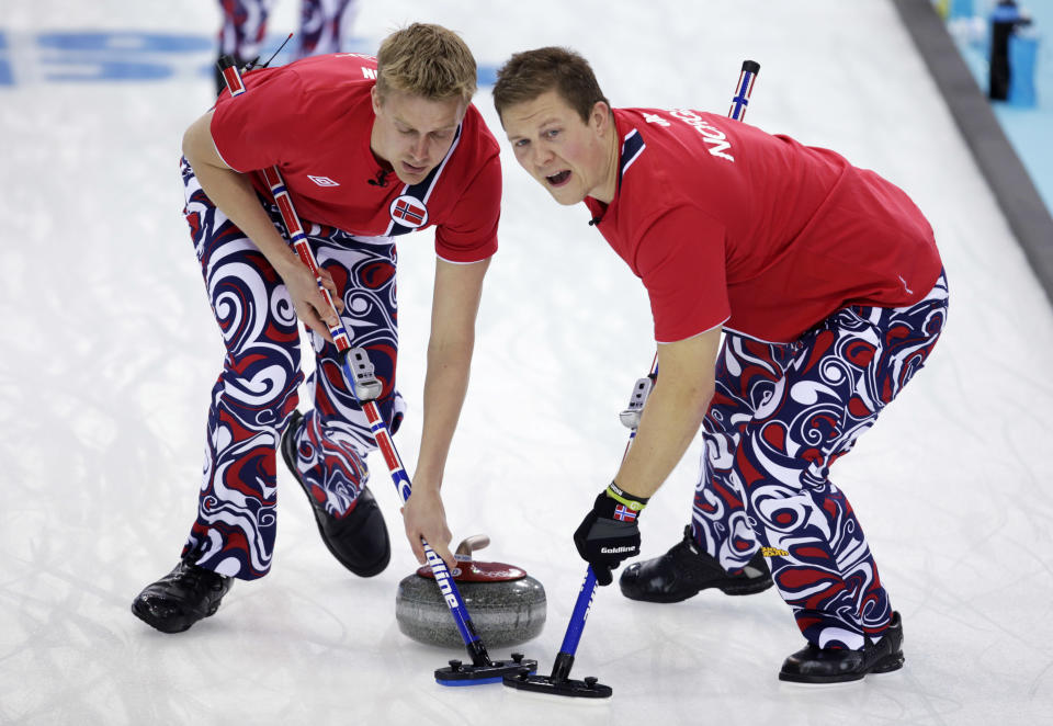 Norway’s Haavard Vad Petersson, left, and Christoffer Svae sweep ahead of the stone during men's curling competition against Denmark at the 2014 Winter Olympics, Monday, Feb. 17, 2014, in Sochi, Russia. (AP Photo/Robert F. Bukaty)