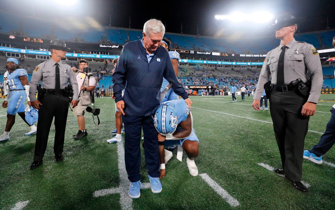 North Carolina head coach Mack Brown checks on running back British Brooks (24), who was brought to tears after UNC’s 31-17 victory over South Carolina in the Duke’s Mayo Classic at Bank of America Stadium in Charlotte, N.C., Saturday, Sept. 2, 2023.