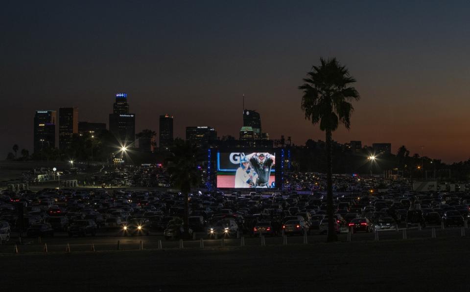 Dodger fans watch the World Series from their cars on big screens set up in the Dodger Stadium parking lot