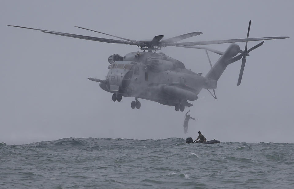 FILE - In this Sept. 20, 2013 file photo, Filipino Marines and U.S. Marines from the 13th Marine Expeditionary Unit BOXER Amphibious Ready Group based in Okinawa, Japan drop from a CH-53 Super Stallion helicopter during a joint military exercise called Philippines-U.S. Amphibious Landing Exercise (PHIBLEX) in Ternate, Cavite province, southern Philippines. A new defense pact that will allow thousands of U.S. troops to be temporarily based in Philippines for the first time in more than 20 years signals closer cooperation in the allies’ hot-and-cold relationship that has been shaped over the decades by war, terrorism and now, jitters over China's rise. The 10-year agreement, signed Monday, April 28, 2014, as President Barack Obama arrived in Manila, was considered the centerpiece of his four-nation Asian trip, which he used to reassure allies like Japan and the Philippines of American military backing as they wrangle with China in increasingly tense territorial disputes. (AP Photo/Aaron Favila, File)