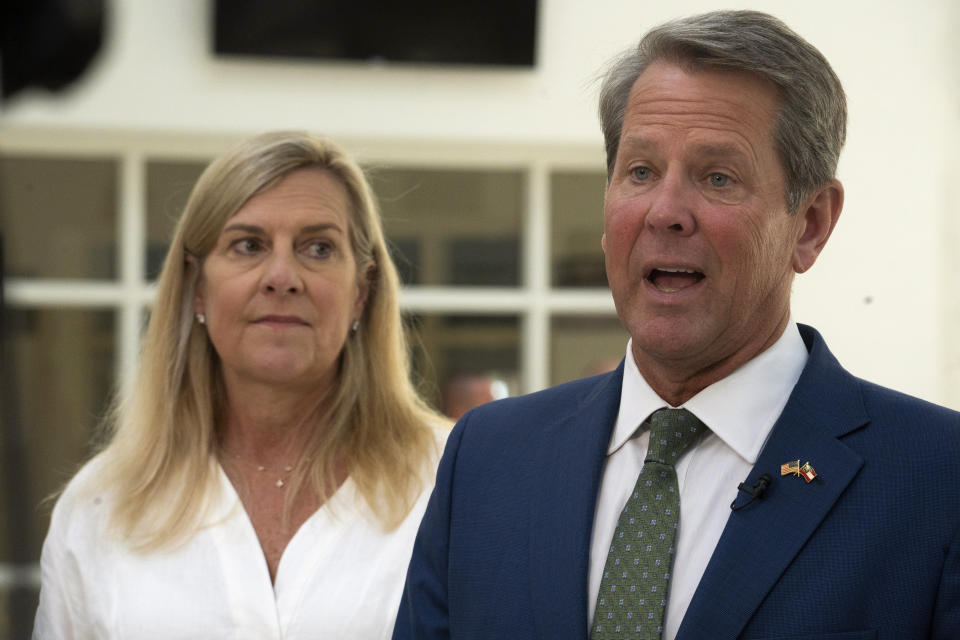 Georgia Gov. Brian Kemp speaks at Ola High School on Friday, July 29, 2022, in McDonough, Ga. Georgia first lady Marty Kemp listens at left. Kemp's decision to defy Donald Trump and ratify Joe Biden's presidential electors in 2020 has won Kemp credit with some Democrats. Heading into the November election, Democratic nominee Stacey Abrams needs those voters in her column. (AP Photo/Megan Varner, File)